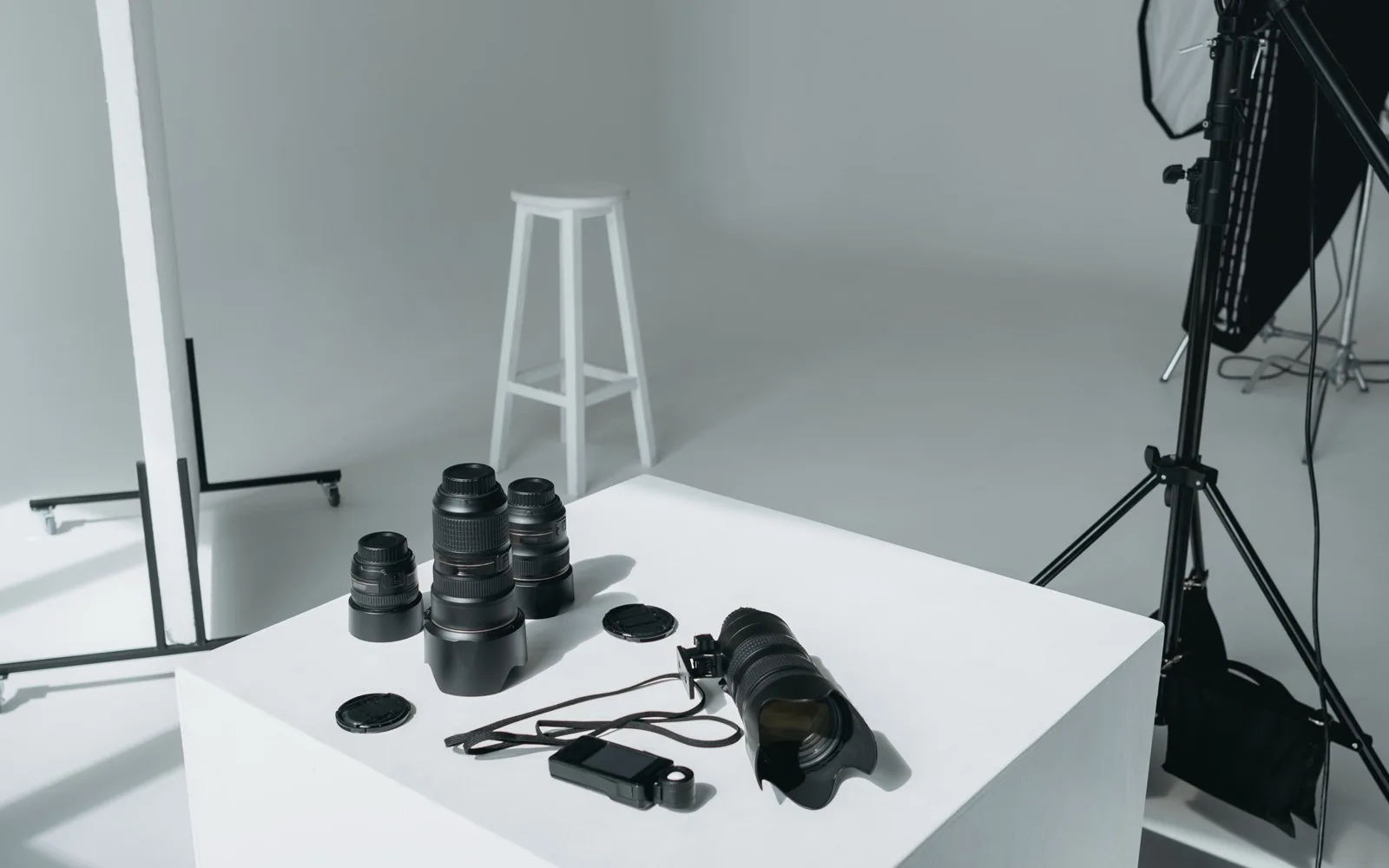 Jednoduché štúdio s fotoaparátmi, objektívmi, svetlami a bielym pozadím pripravené na produktové fotografovanie