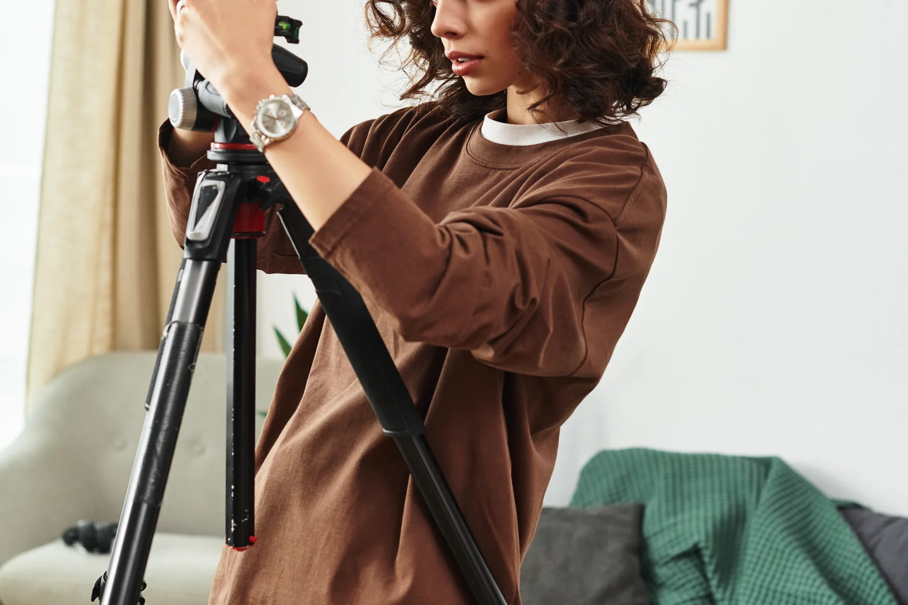 Žena nastavuje fotoaparát na statíve pred fotografovaním autoportrétu