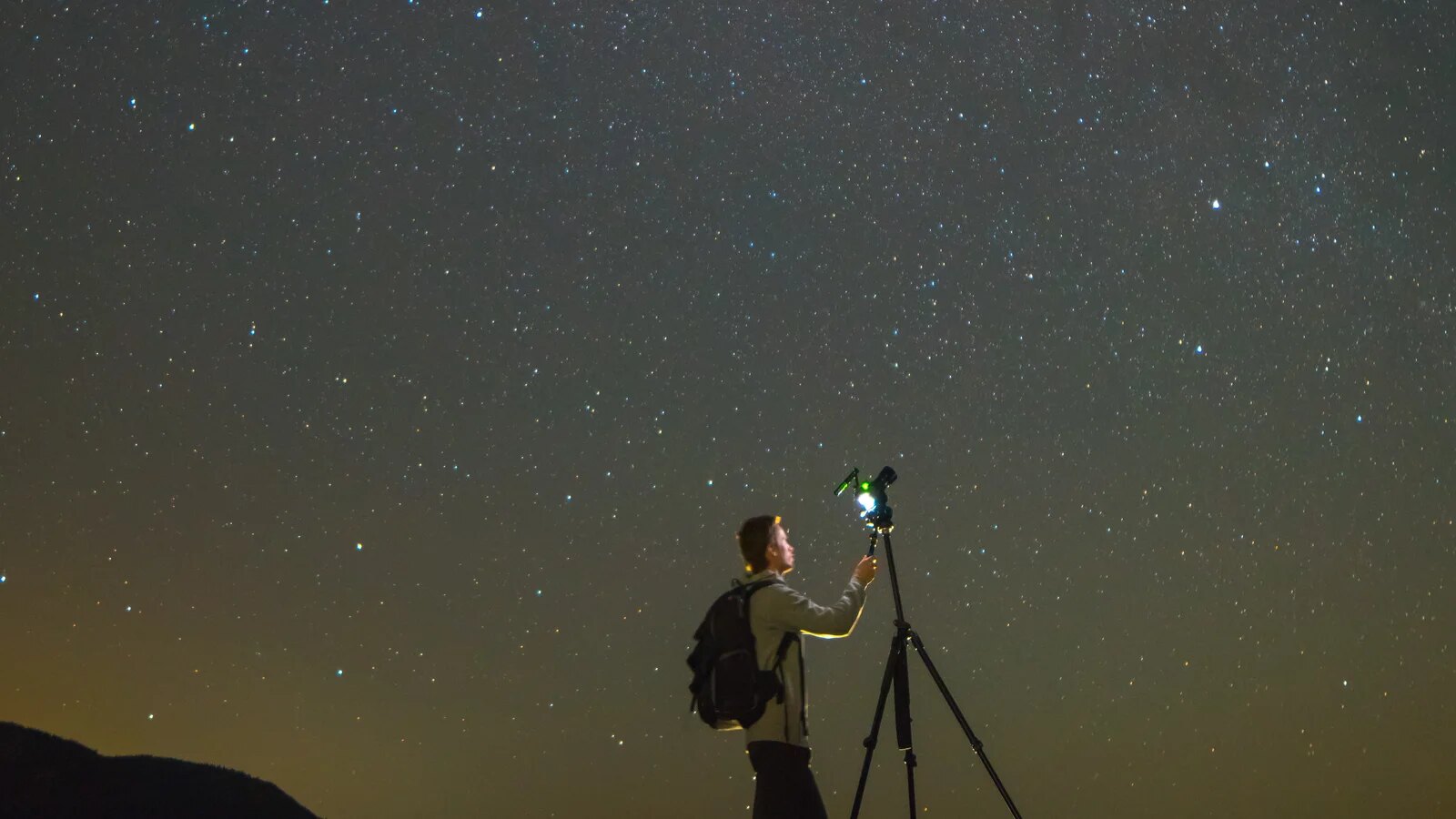 Fotoaparát na statíve pri nočnom fotografovaní osvetleného mesta