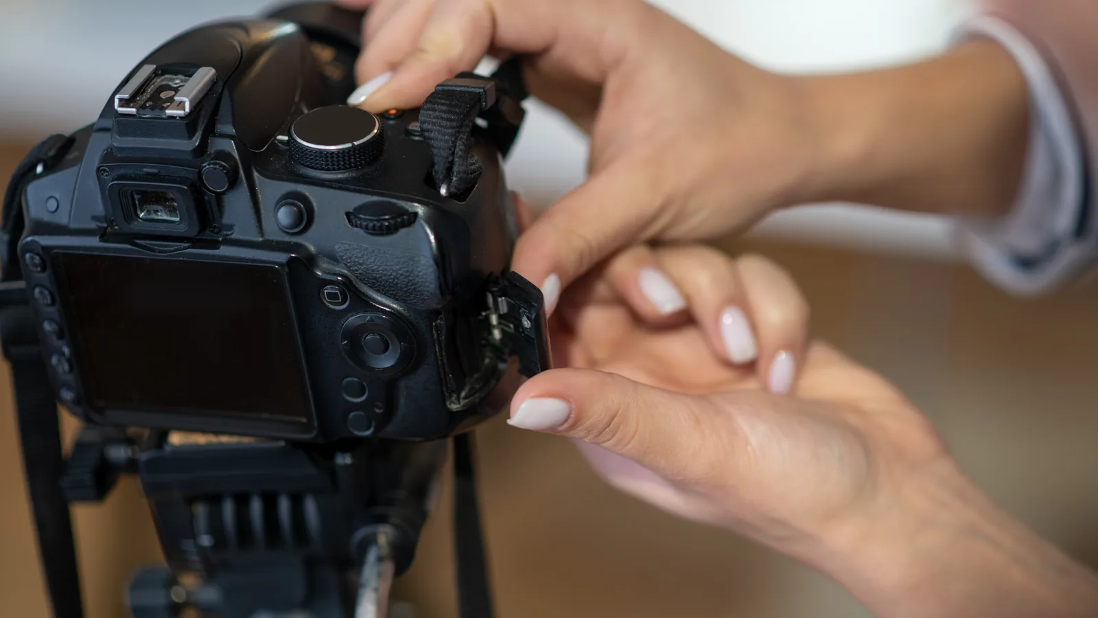 Ruky nastavujú digitálny fotoaparát upevnený na statíve