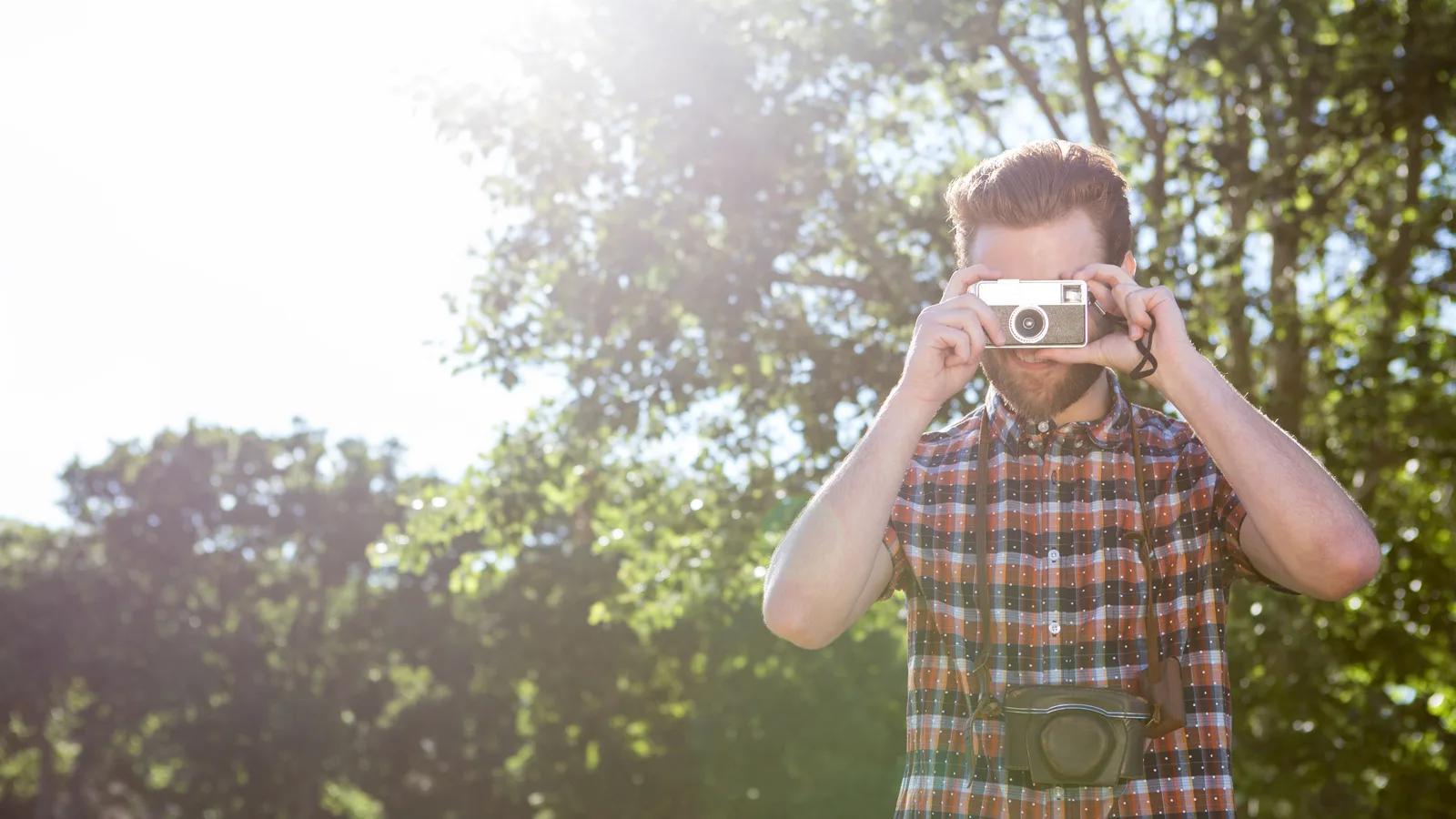 Fotograf fotografuje v lese v prirodzenom protisvetle