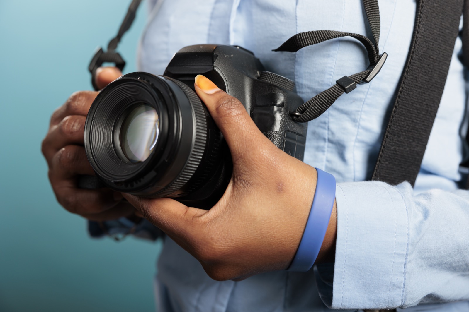 Ruky držiace digitálny fotoaparát s objektívom
