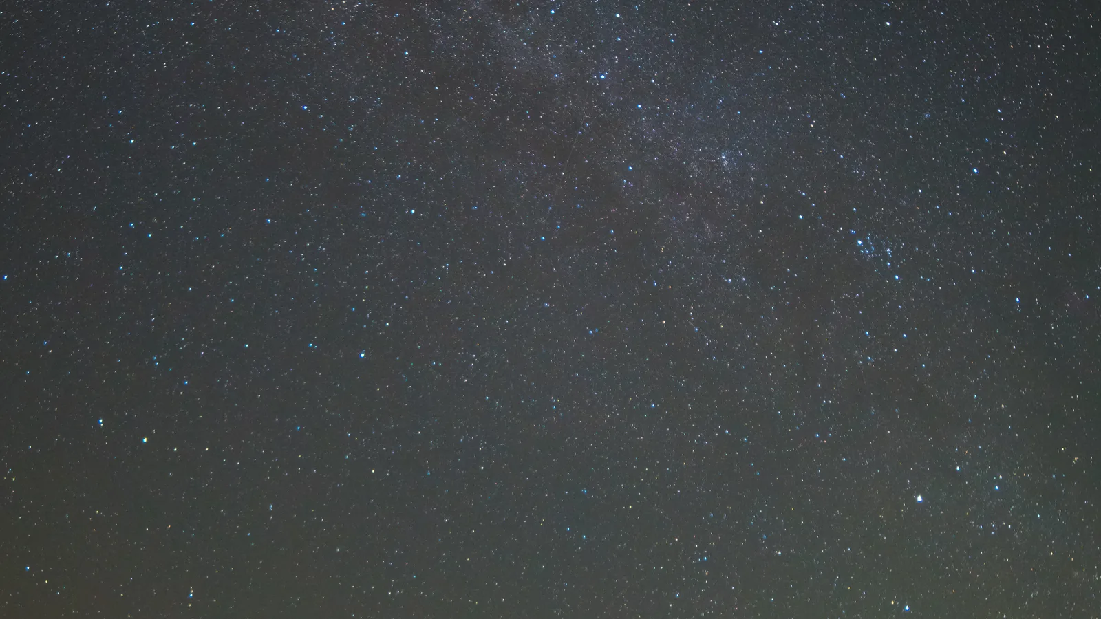 Fotograf pri nočnom fotografovaní pod hviezdnou oblohou