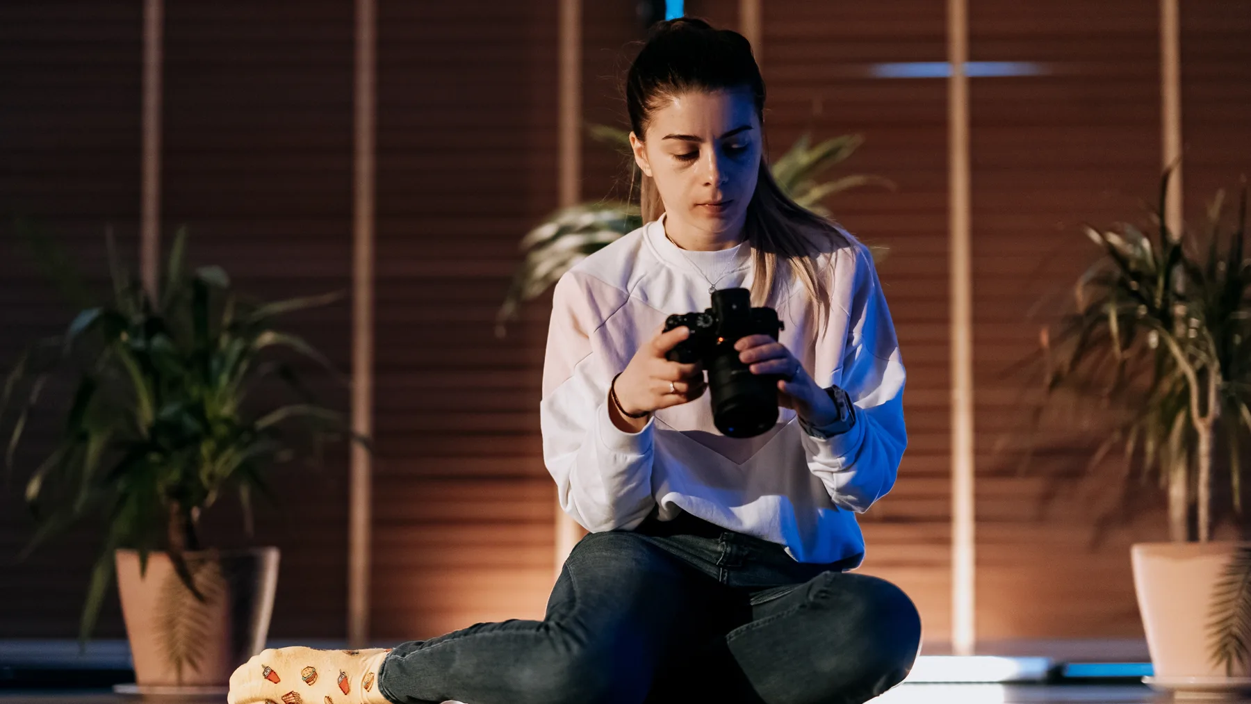 Fotografka kontroluje fotoaparát pri slabom svetle v interiéri