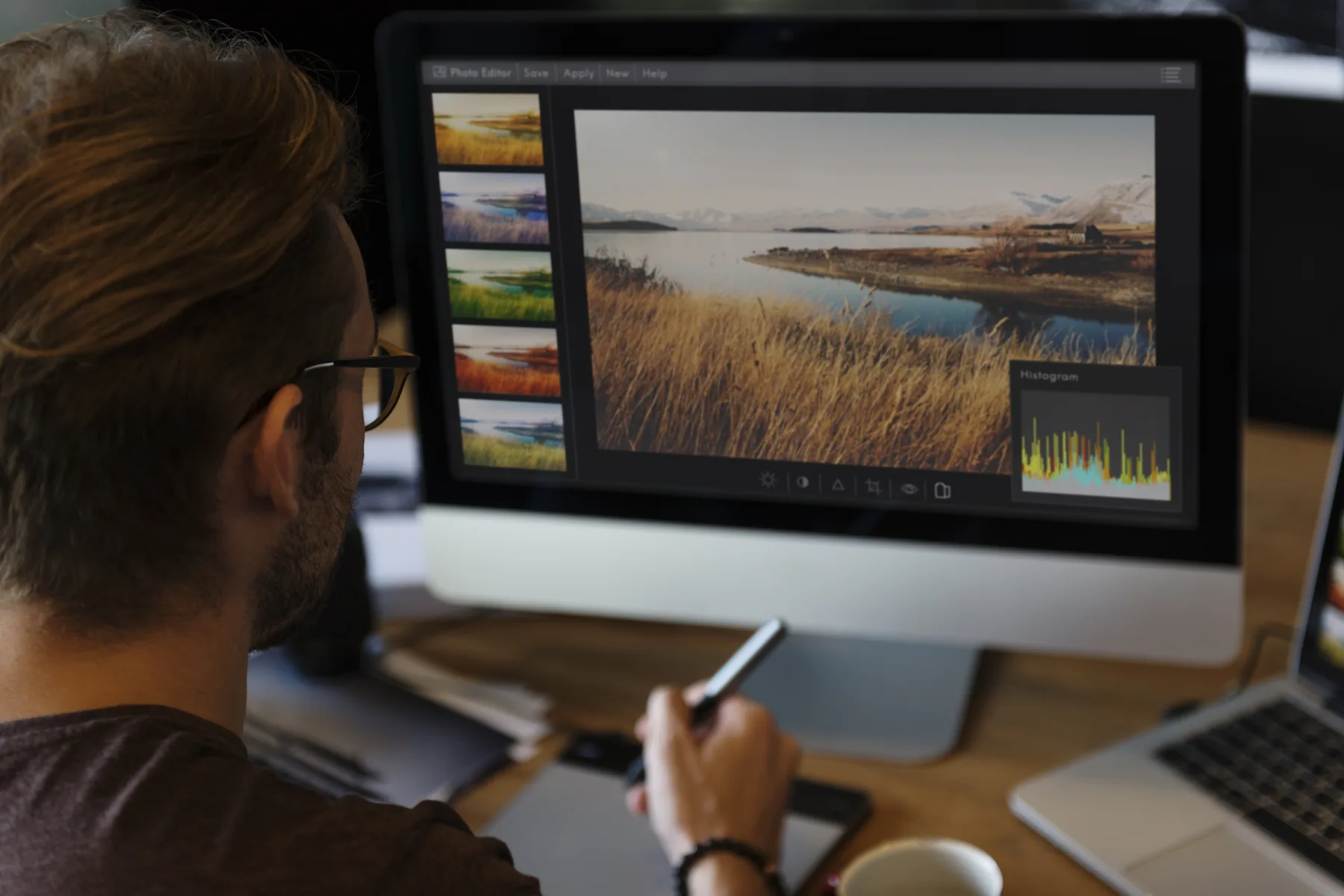 Fotograf upravuje krajinnú fotografiu na veľkom počítačovom monitore