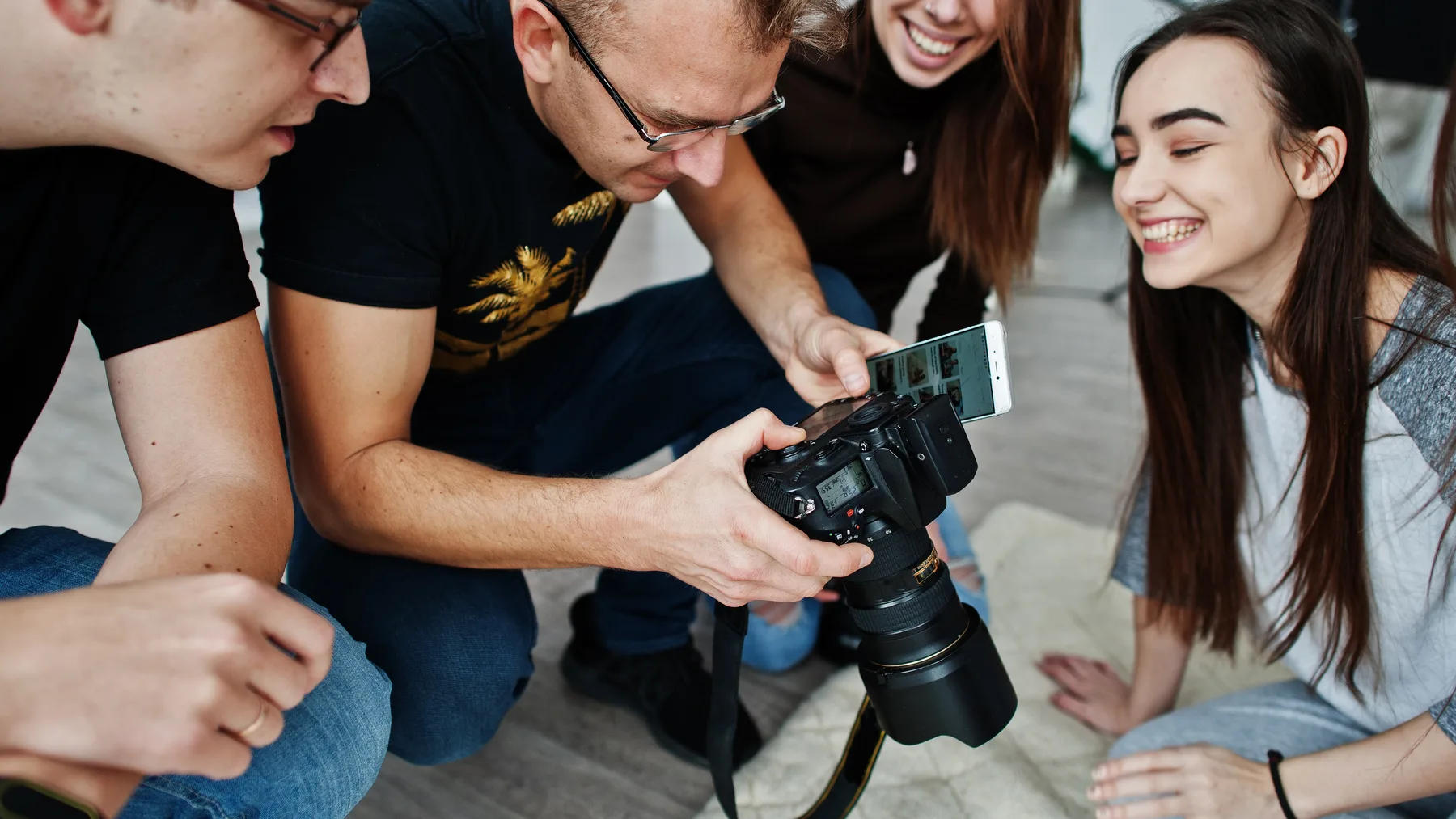 Skupina fotografov spoločne kontroluje zábery na displeji fotoaparátu
