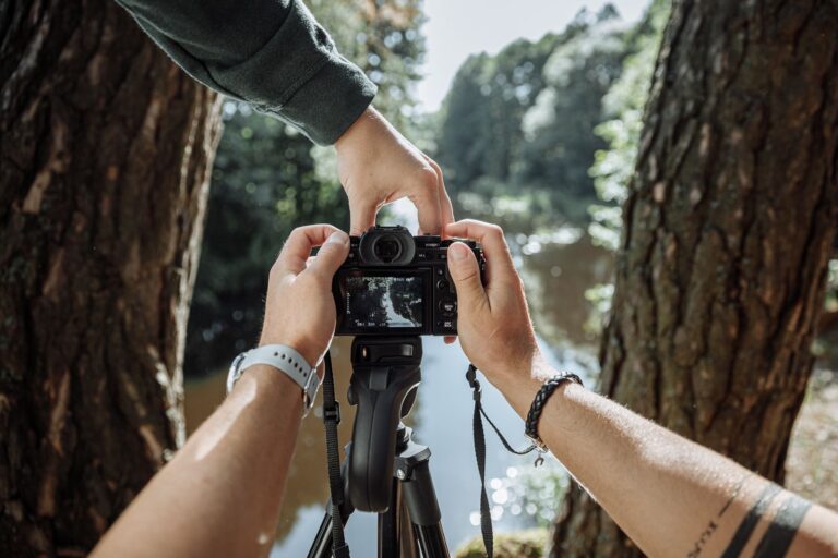 Fotograf nastavuje digitálny fotoaparát upevnený na statíve pri fotografovaní v prírode