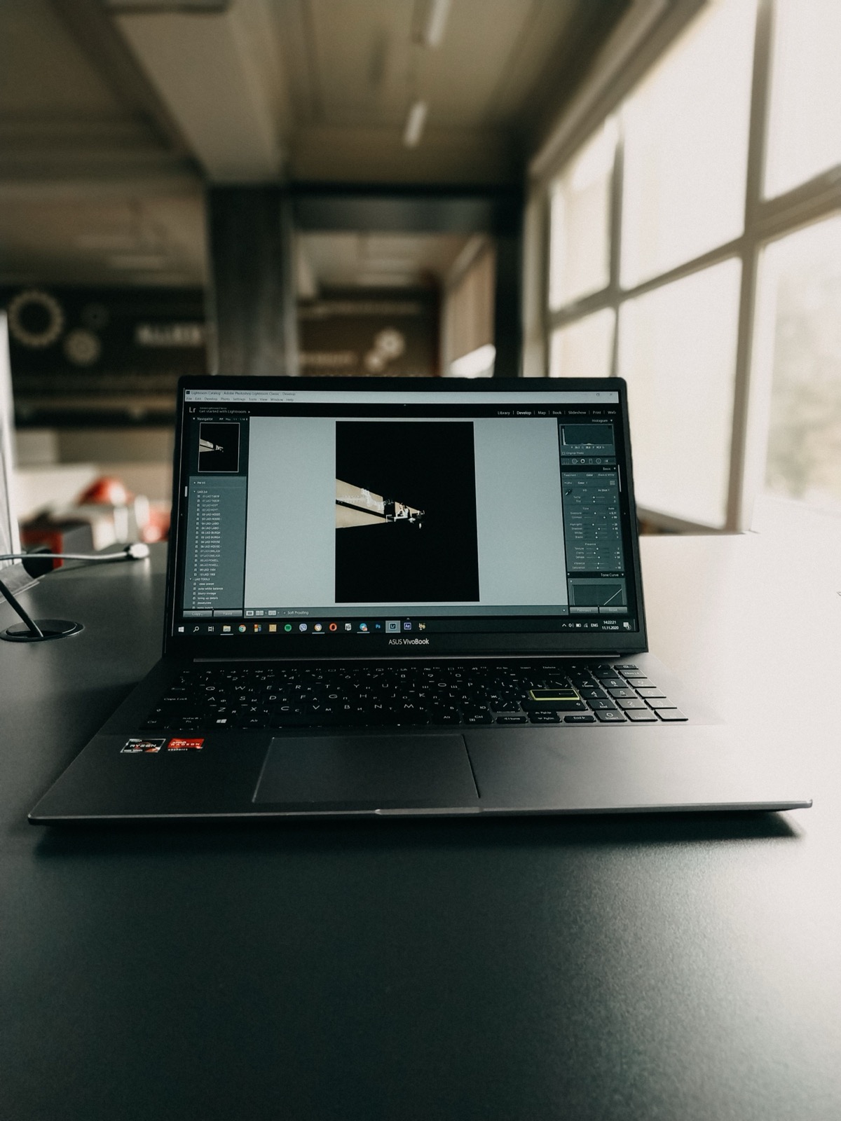 Notebook s otvoreným fotografickým editorom na pracovnom stole